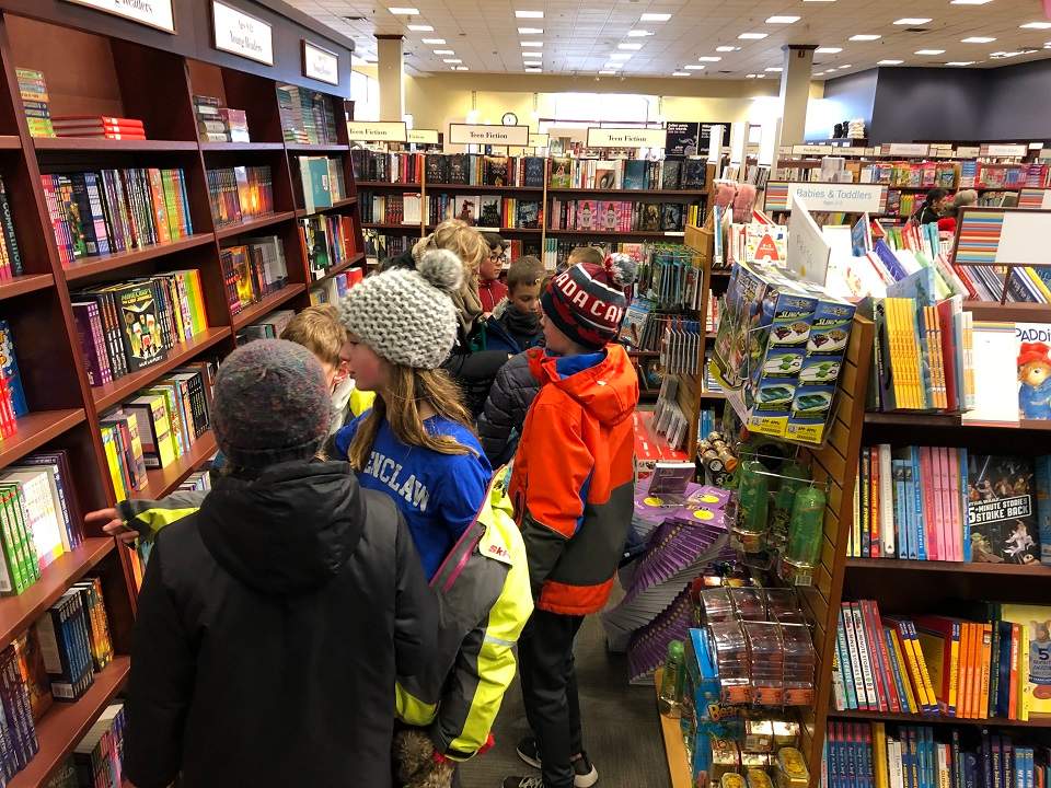 Keenooshayo Elementary School students picking out books for their project