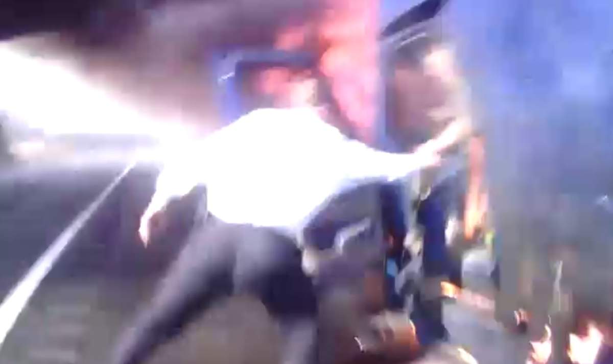 This still image from body-camera video shows State Police Lt. Edward Ryer helping a driver out of a burning tractor-trailer near Bridgewater Township, N.J., on March 2, 2020.