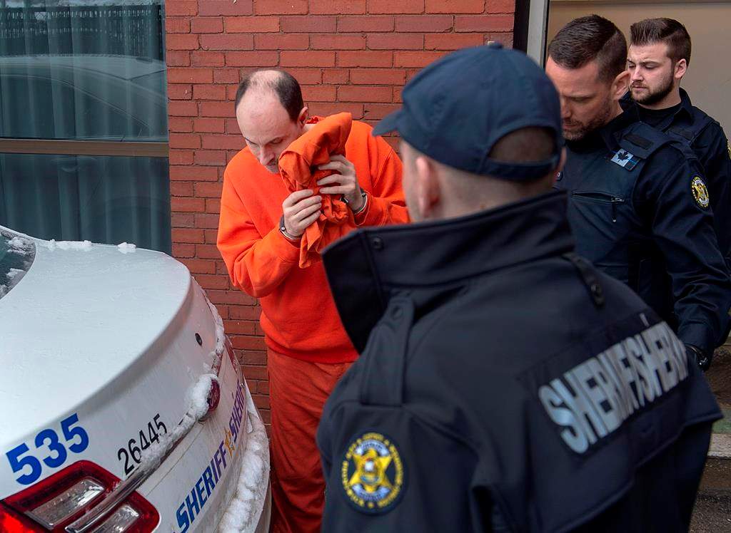 Matthew Vincent Raymond is taken from Court of Queen's Bench in Fredericton on Friday, March 13, 2020. The trial for Raymond, accused of killing two police officers and two civilians in the New Brunswick capital last year, is still an uncertainty as the state of his mental health is being considered. The province is also is suspending jury trials for two months over concerns about the potential spread of novel coronavirus. THE CANADIAN PRESS/Andrew Vaughan.