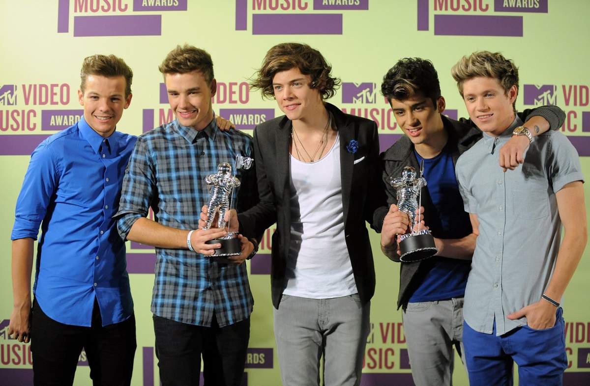 One Direction, from left, Louis Tomlinson, Liam Payne, Harry Styles, Zayn Malik and Niall Horan pose backstage after winning the awards for Best New Artist and Best Pop Video for the track, ‘What Makes You Beautiful’ at the MTV Video Music Awards, in Los Angeles, Calif.