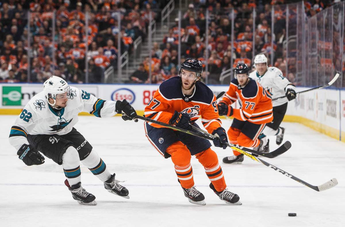 San Jose Sharks' Kevin Labanc (62) chases Edmonton Oilers' Connor McDavid (97) during second period NHL action in Edmonton, Thursday, Feb. 6, 2020. THE CANADIAN PRESS/Jason Franson.