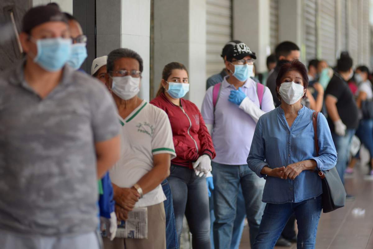 Citizens with face masks line up at a supermarket in Guayaquil, Ecuador, 24 March 2020.