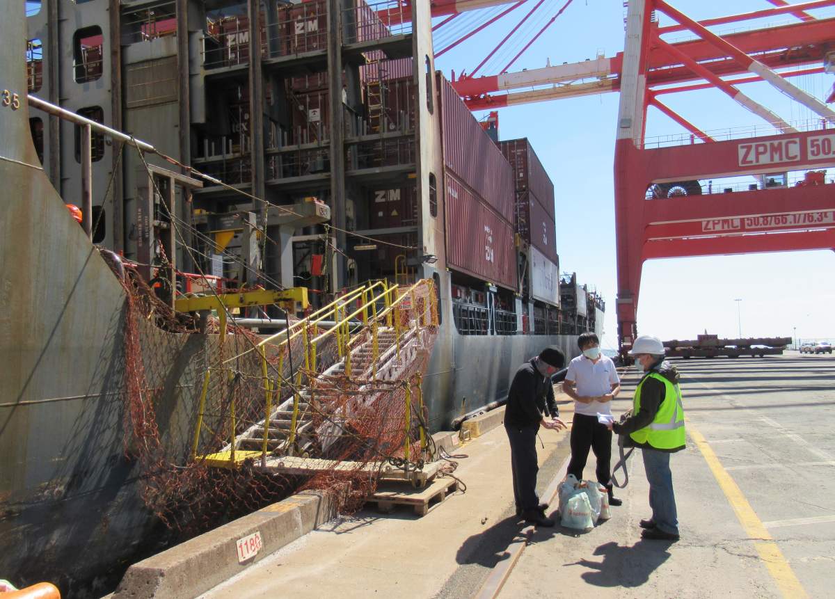 Mission to Seafarers volunteer Joseph Loot, right, delivering provisions and SIM cards to crew aboard the container ship Hansa Meersburg in Halifax on Sunday April 5, 2020. 