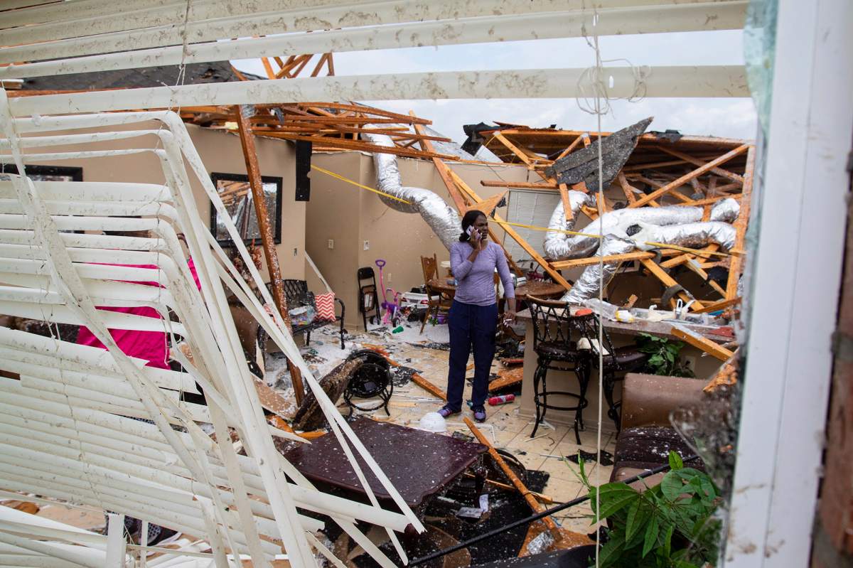 Rolanda Robinson calls family and friends from her brother's damaged home in Monroe, La. after a tornado ripped through the town on Sunday, April 12, 2020.