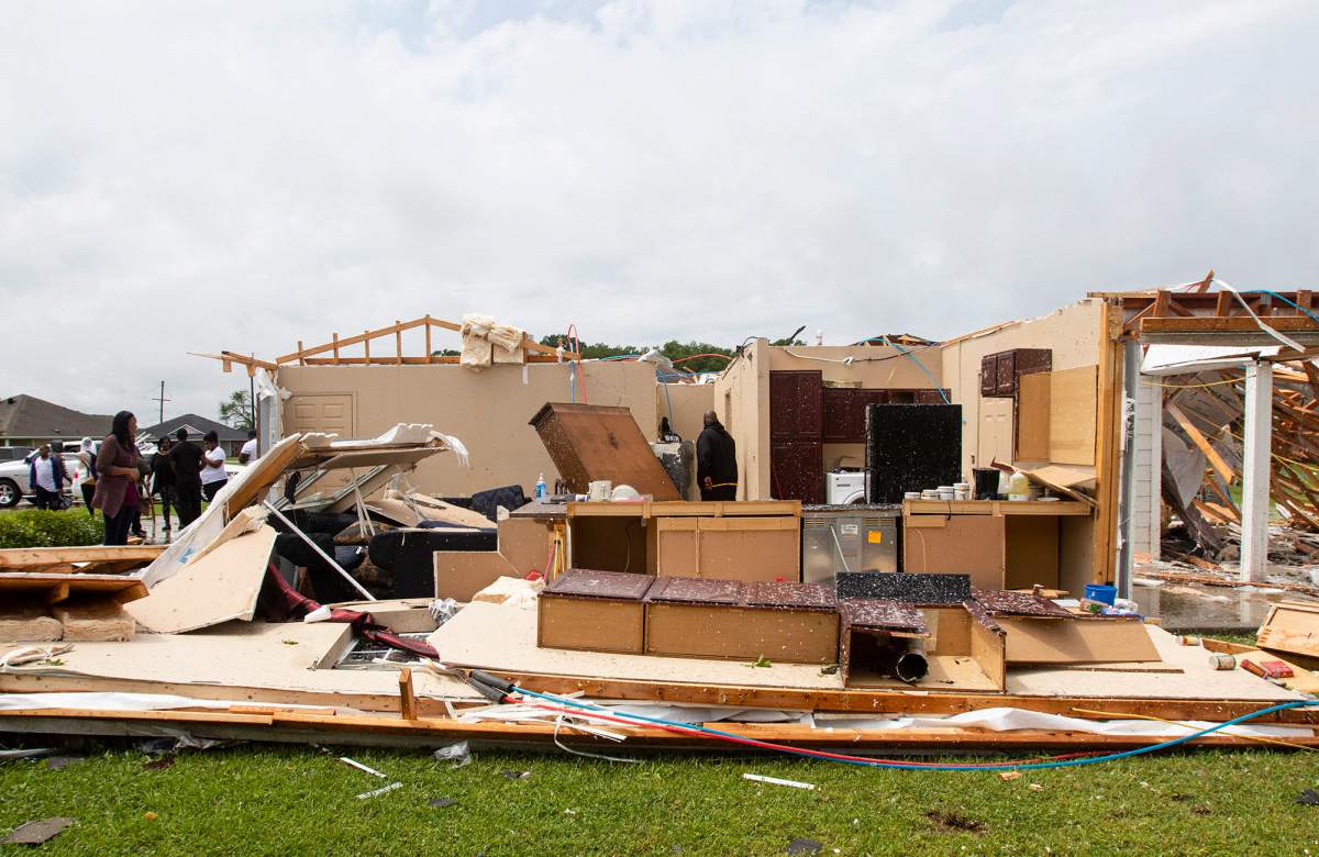 Neighbours inspect a house for occupants in Monroe, La. after an Easter tornado ripped through the town just before noon on Sunday, April 12, 2020. (Nicolas Galindo/The News-Star via AP)