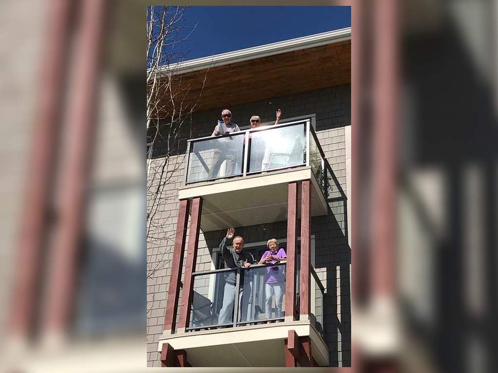 Residents at Amica Aspen Woods gather on their balconies for choir practice.