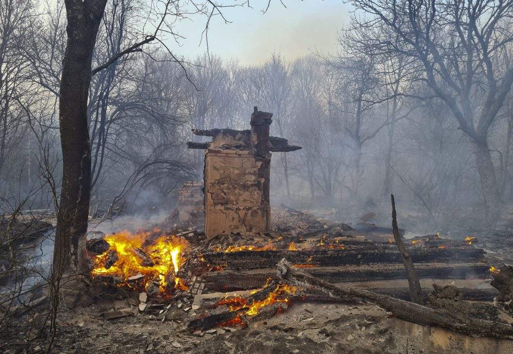 An uninhabited house burns in the middle of a forest fire near the village of Volodymyrivka, in the exclusion zone around the Chernobyl nuclear power plant, Ukraine, on Sunday, April 5, 2020.