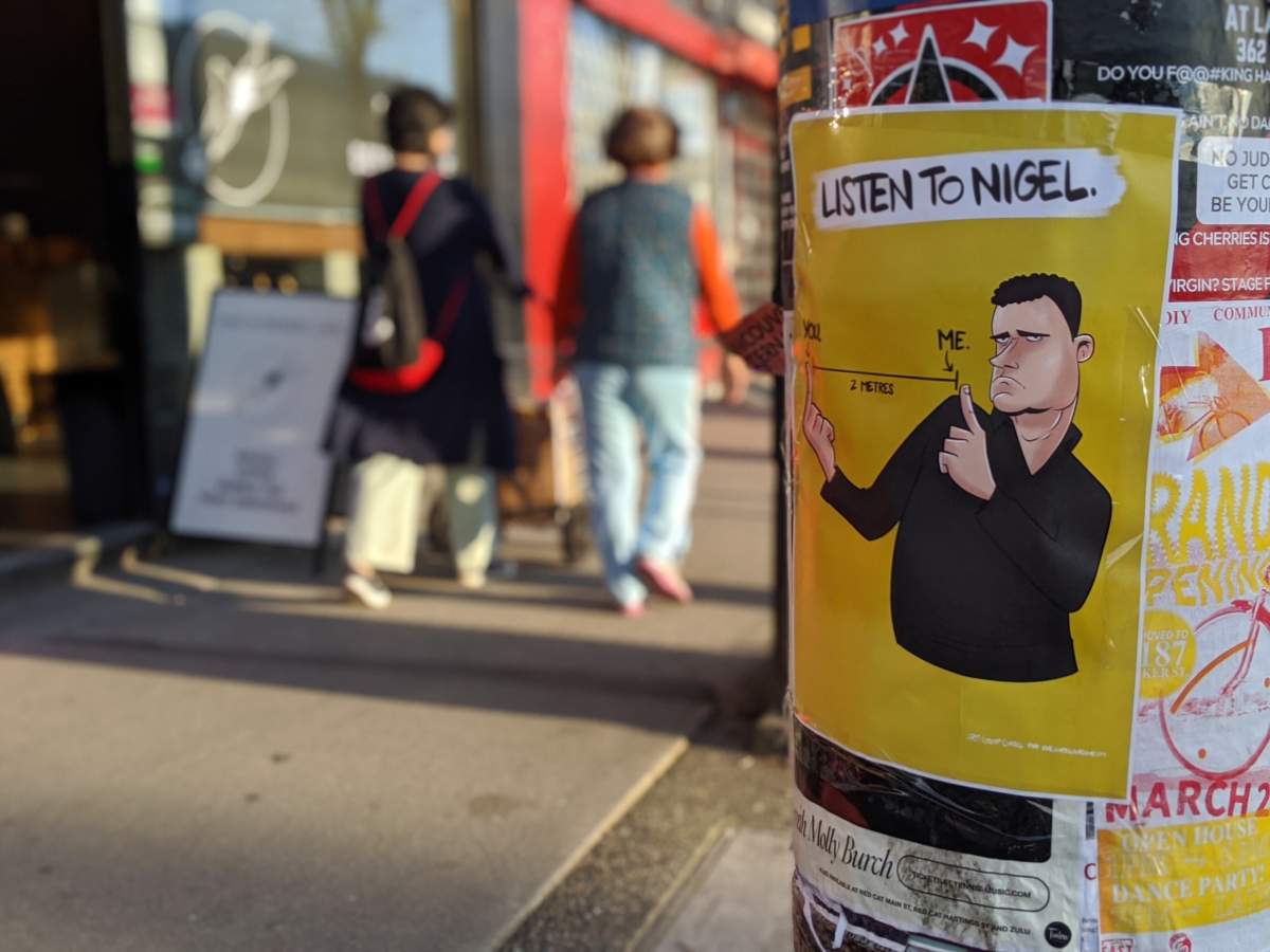 A poster shows B.C. ASL sign language interpreter Nigel Howard reminding the public to keep two metres apart during the COVID-19 pandemic.