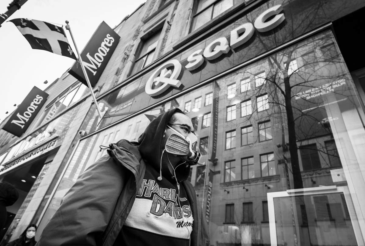 A client wears a mask as he waits in line at the SQDC store on Ste-Catherine Street, Tuesday March 24, 2020. Phil Carpenter/Global News