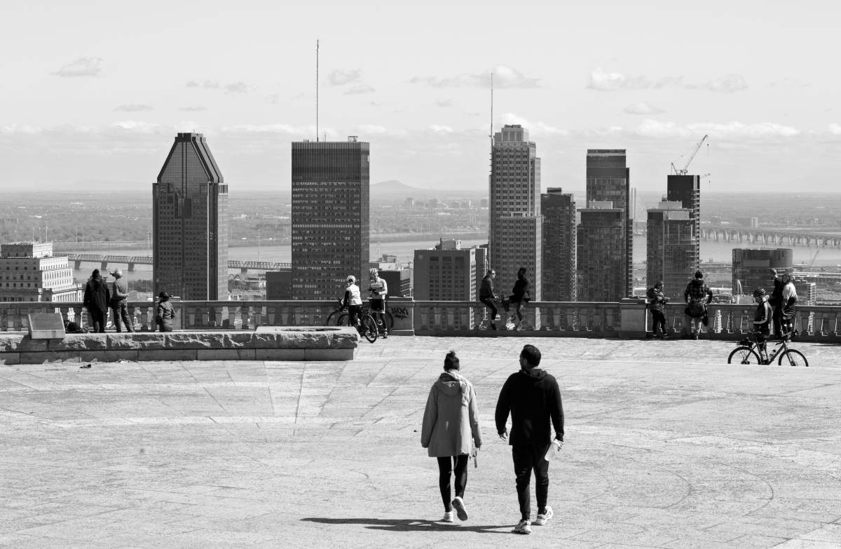 Park goers gather in pairs as they observe physical distancing protocol while visiting the Belvedere at Mont Royal Park, Sunday April 4, 2020. The following day the parking lot to the area was closed to dissuade visitors. Authorities said too many people were coming from outside the area, leading to crowding at the park. Phil Carpenter/Global News