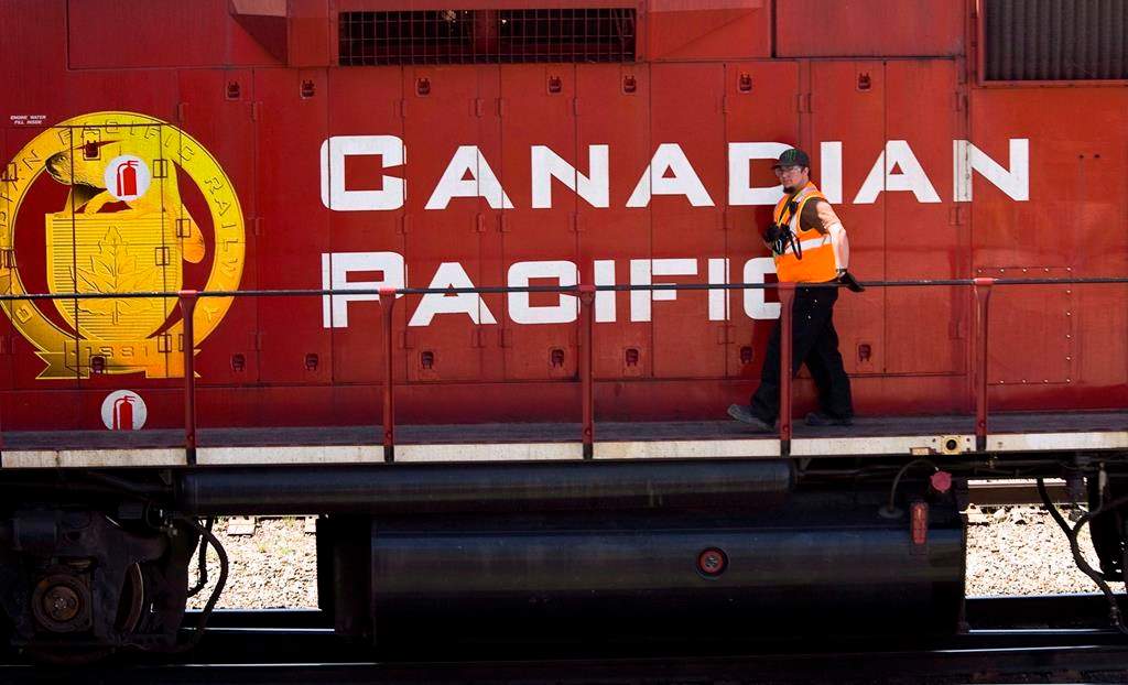 A Canadian Pacific Railway employee walks along the side of a locomotive in a marshalling yard in Calgary, Wednesday, May 16, 2012.