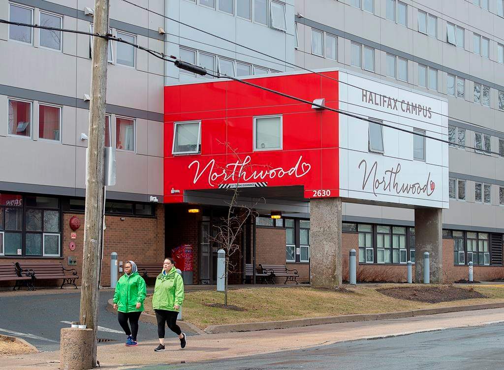 Two women walk past Northwood Manor in Halifax on Monday, April 13, 2020.