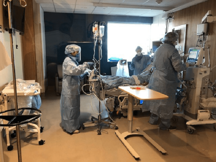 Healthcare workers dressed in personal protective equipment while tending to a patient at Humber River Hospital.