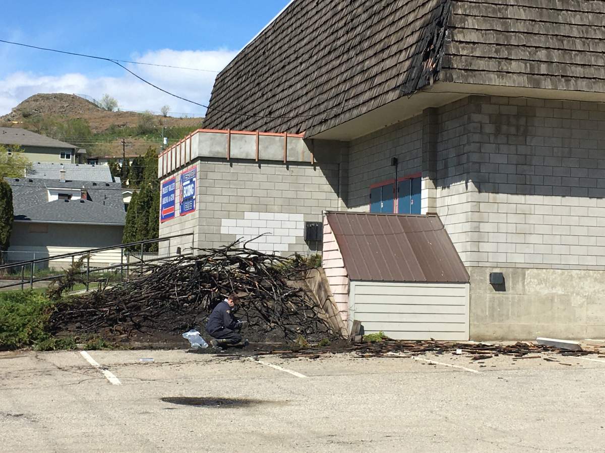 A fire investigator combs through the debris of a structure fire at a Vernon gym.