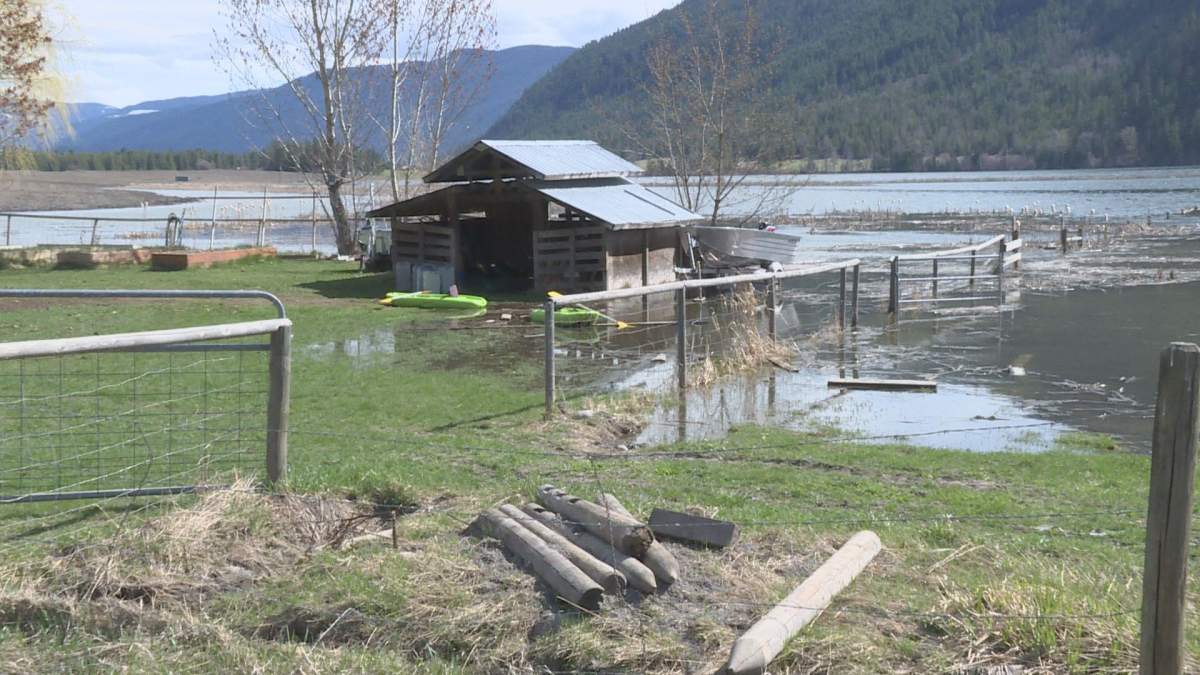 Flood waters from Rawlings Lake flow into a yard.