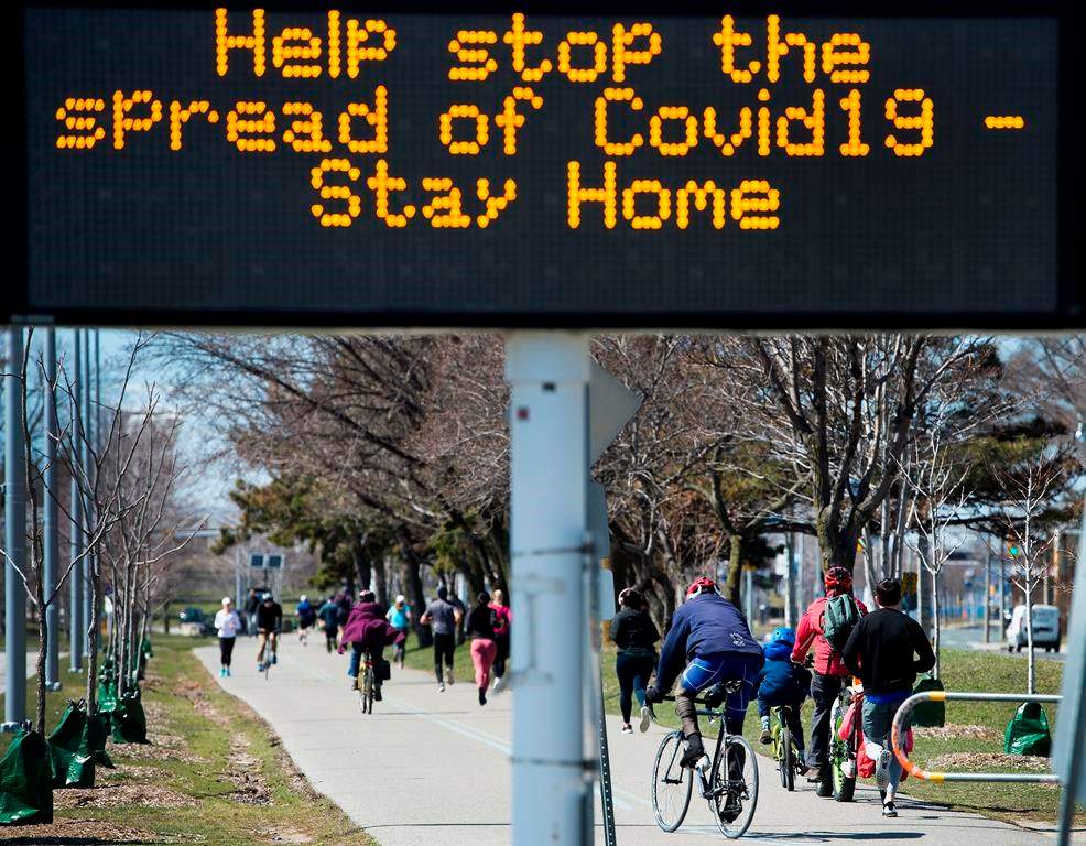 People get exercise outside on the lake shore path along Lake Ontario in Toronto on Thursday, April 2, 2020. Health officials and the government has asks that people stay inside to help curb the spread of the coronavirus also known as COVID-19. THE CANADIAN PRESS/Nathan Denette.