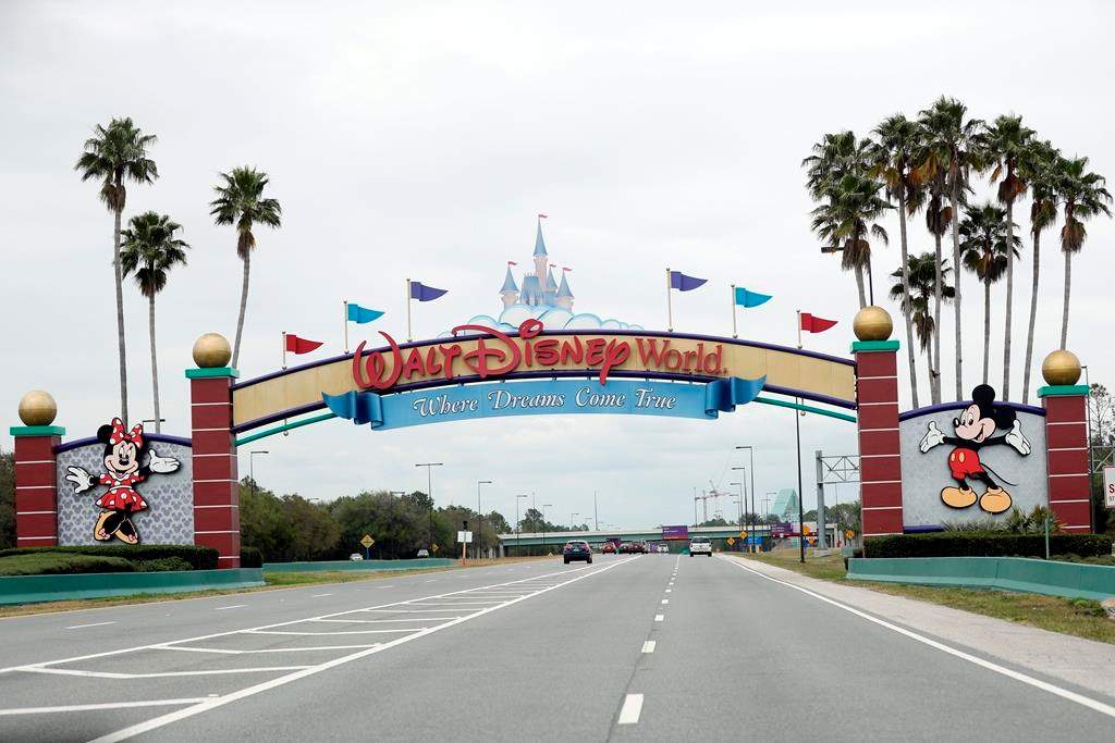 In this March 16, 2020, file photo, the road to the entrance of Walt Disney World has few cars, in Lake Buena Vista, Fla.