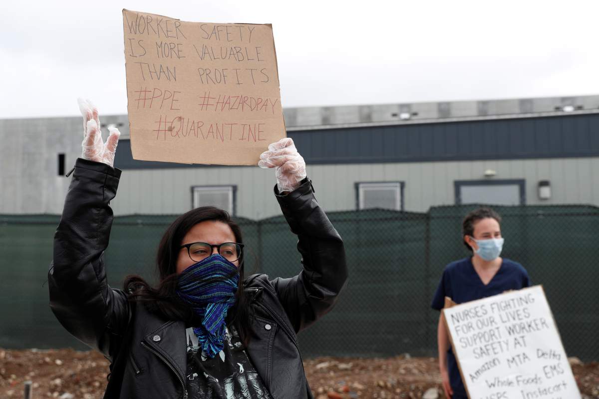 Demonstrators hold signs during a protest outside of an Amazon warehouse as the outbreak of the coronavirus disease (COVID-19) continues in the Staten Island borough of New York U.S., May 1, 2020. REUTERS/Lucas Jackson
