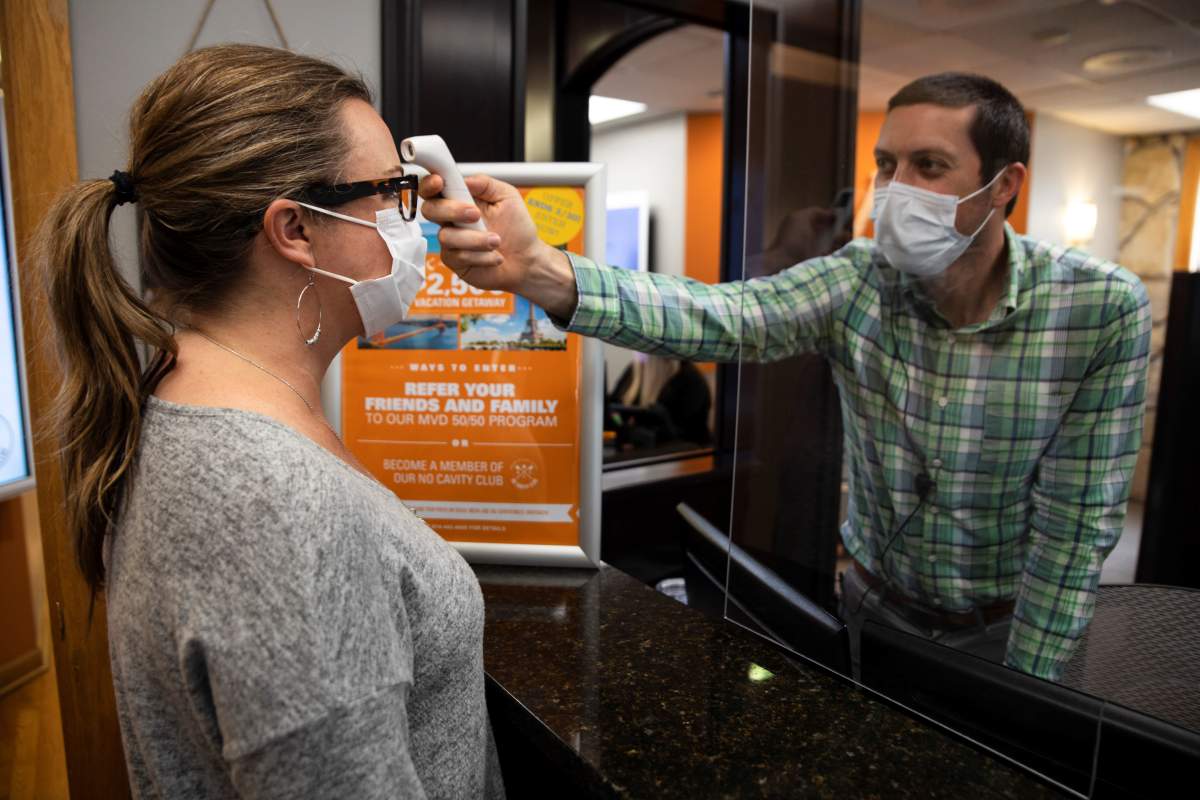 A dentist office manager takes the temperature of a woman as Ohio implements phase one of reopening dentists, veterinarians and elective surgeries, following the outbreak of the coronavirus disease (COVID-19), in Columbus, Ohio, U.S., May 01, 2020. REUTERS/Megan Jelinger