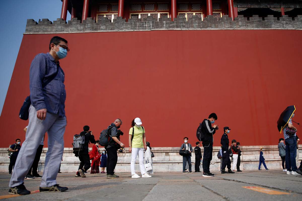 Visitors wearing face masks practise social distancing as they line up to enter the Forbidden City before its reopening on the first day of the five-day Labour Day holiday following the coronavirus disease (COVID-19) outbreak, in Beijing, China May 1, 2020.