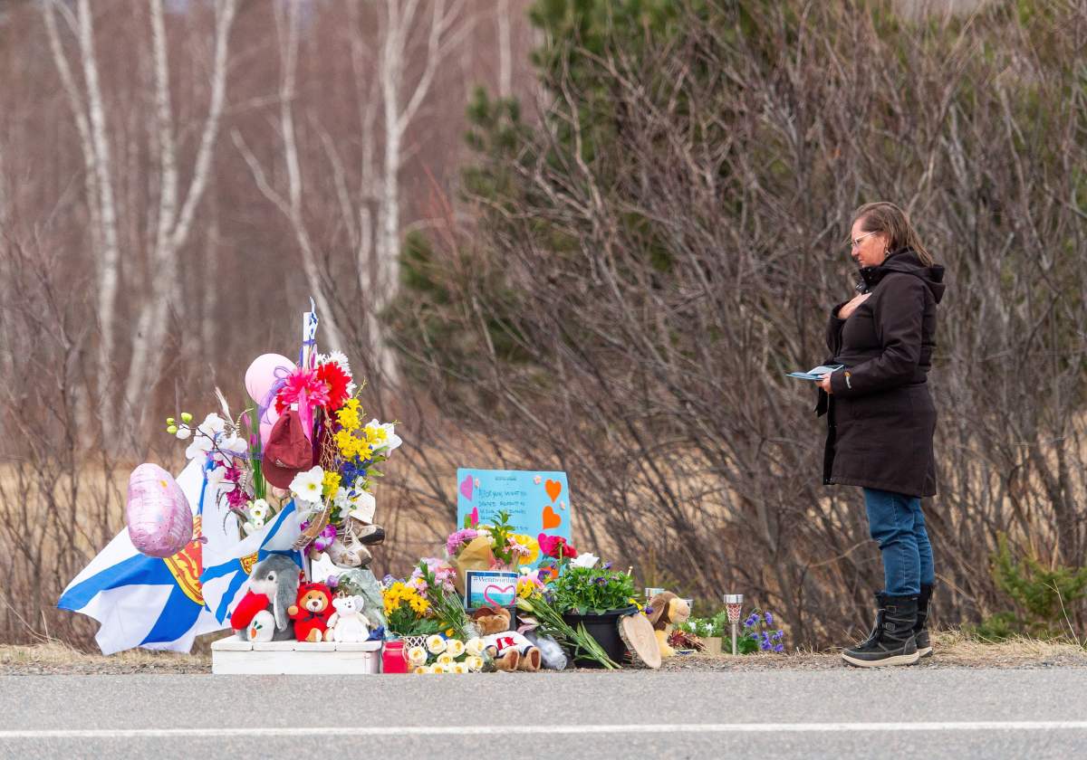 Christine Heart stops to pay her respects at a roadside memorial for Lillian Hyslop in Wentworth, N.S., on April 24, 2020. Twenty-two people are dead after a man went on a murderous rampage in Portapique and several other Nova Scotia communities.