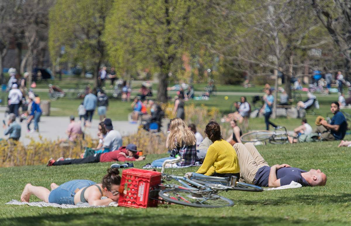 People gather in a city park on a warm sunny day in Montreal, Monday, May 18, 2020, as the COVID-19 pandemic continues in Canada and around the world.