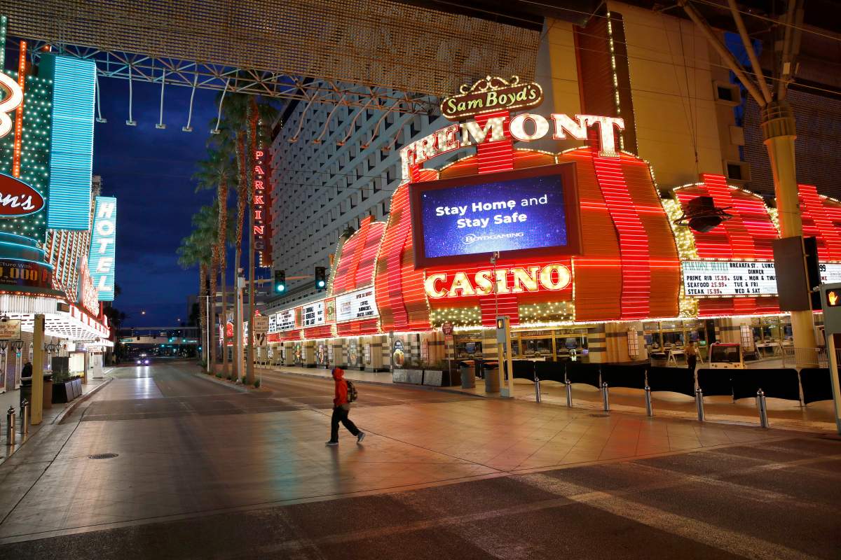 FILE - In this March 21, 2020, file photo, a man walks along a usually busy Fremont Street after casinos were ordered to shut down due to the coronavirus outbreak in Las Vegas.