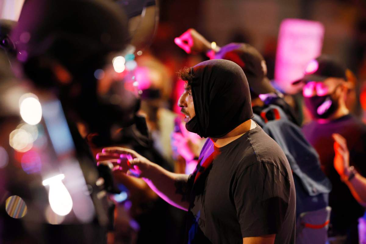 A man argues with Denver police officers during a protest outside the State Capitol over the death of George Floyd, a handcuffed black man in police custody in Minneapolis, late Thursday, May 28, 2020, in Denver. (AP Photo/David Zalubowski)