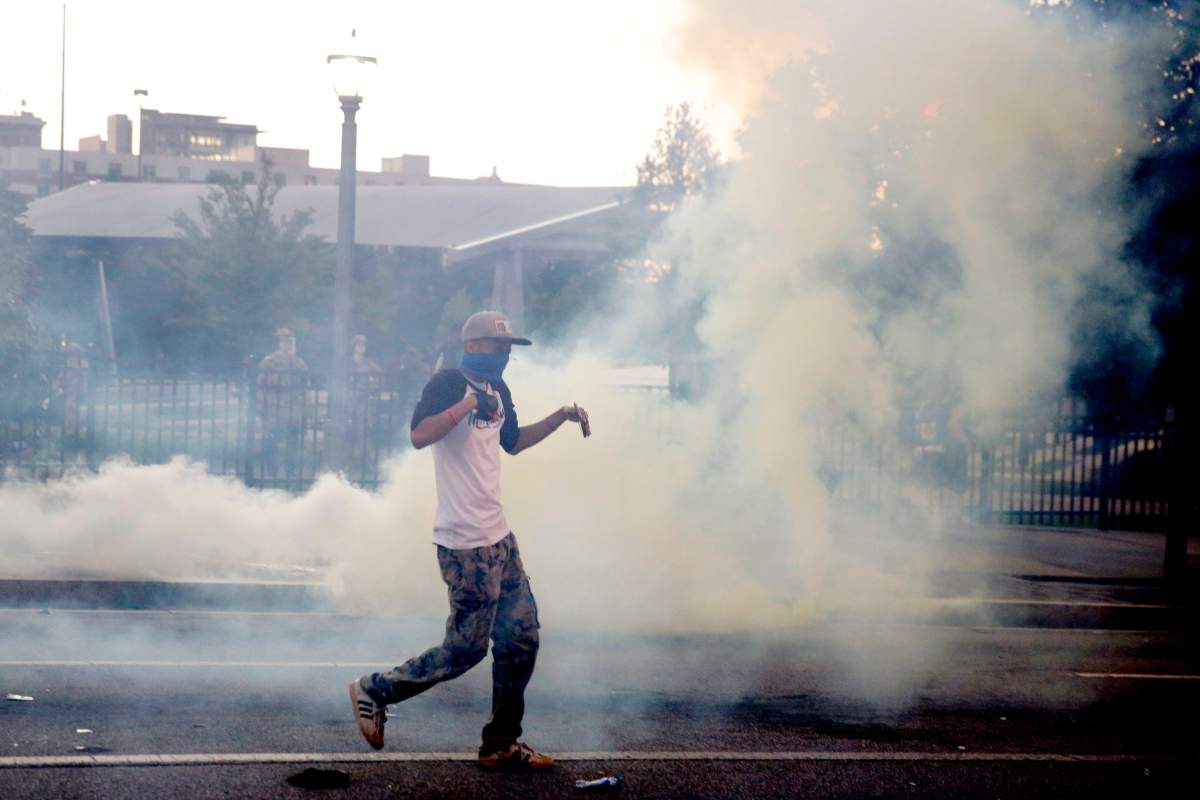 Demonstrators protest in a fog of gas that the Atlanta Police launched at a crowd, Saturday, May 30, 2020 in Atlanta.