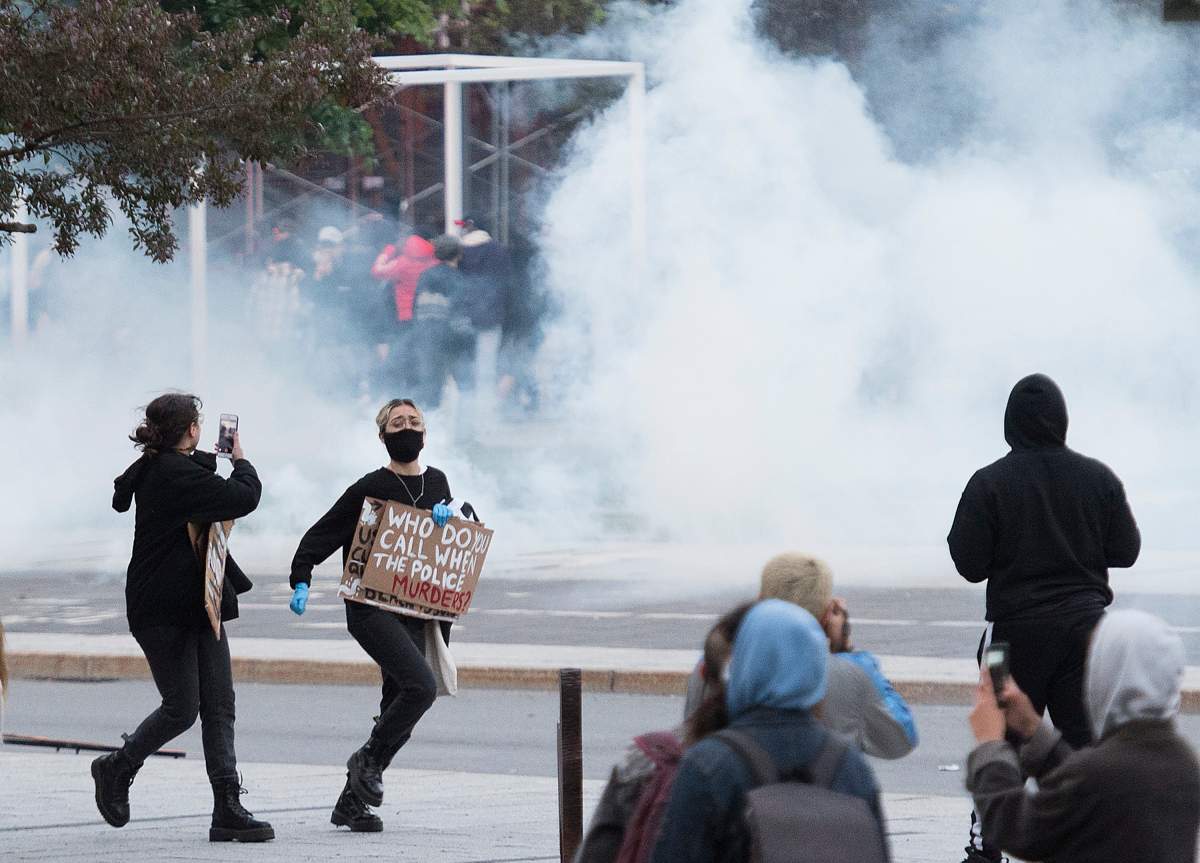 Protesters run from police during a demonstration calling for justice in the death of George Floyd and victims of police brutality in Montreal, Sunday, May 31, 2020. THE CANADIAN PRESS/Graham Hughes