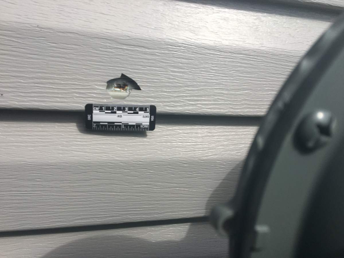 A bullet misses a gas line and meter by a few inches.