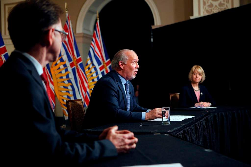 Premier John Horgan is joined by Provincial Health Officer Dr. Bonnie Henry and Health Minister Adrian Dix as they discuss reopening the province's economy in phases in response to the COVID-19 pandemic during a press conference in the rotunda at Legislature in Victoria, B.C., on Wednesday May 6, 2020.