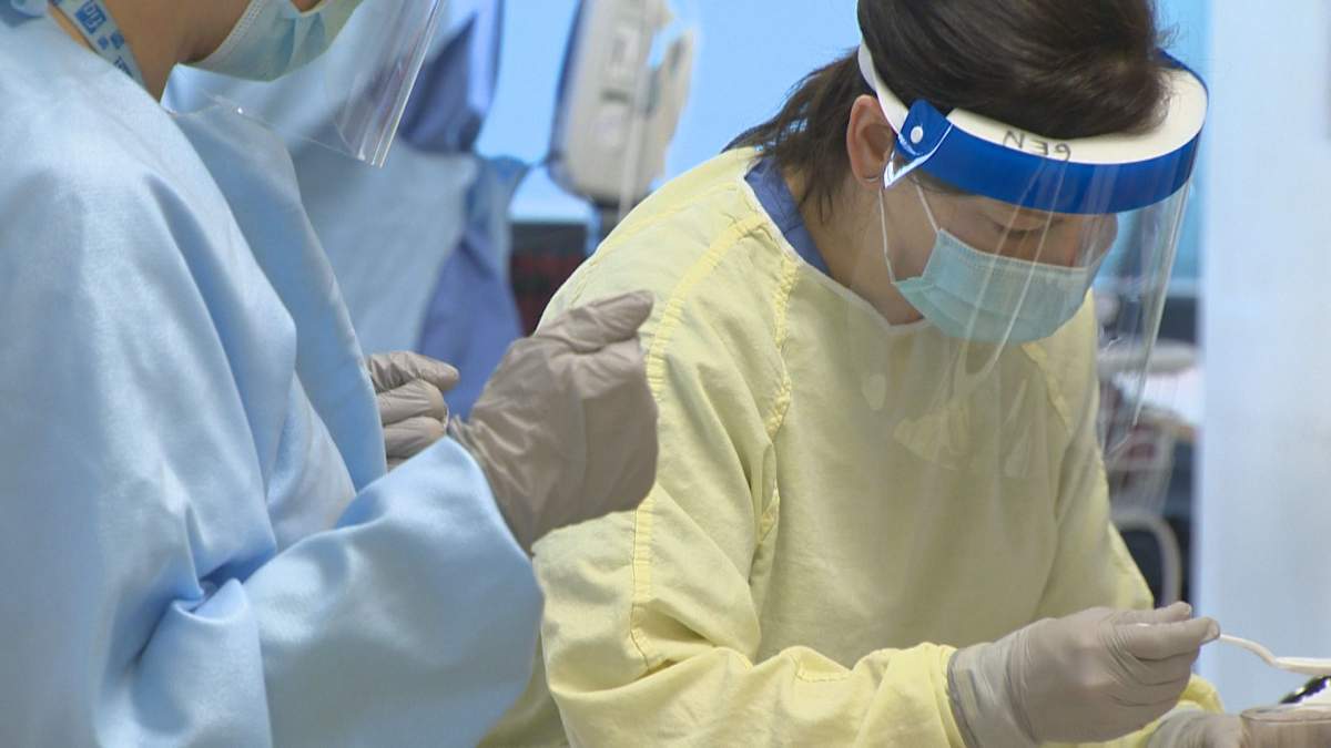 Health care workers treating a COVID-19 patient at the Douglas Hospital
