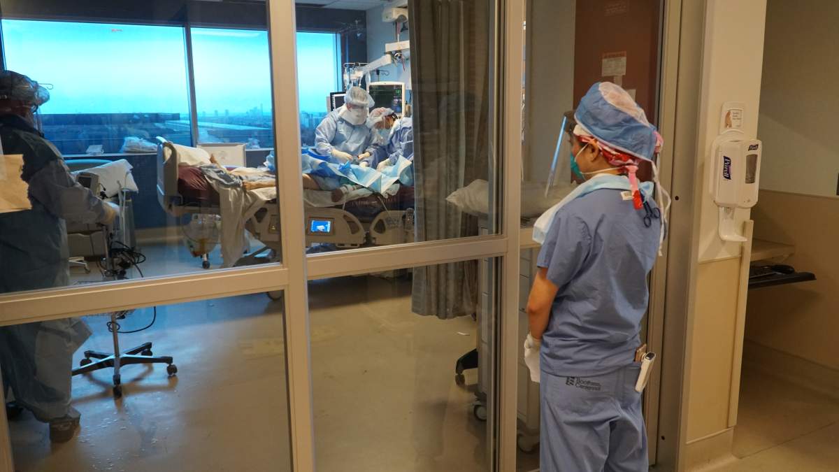Fewer staff are allowed inside the patient’s room, while others stand watch outside in case anything goes wrong.