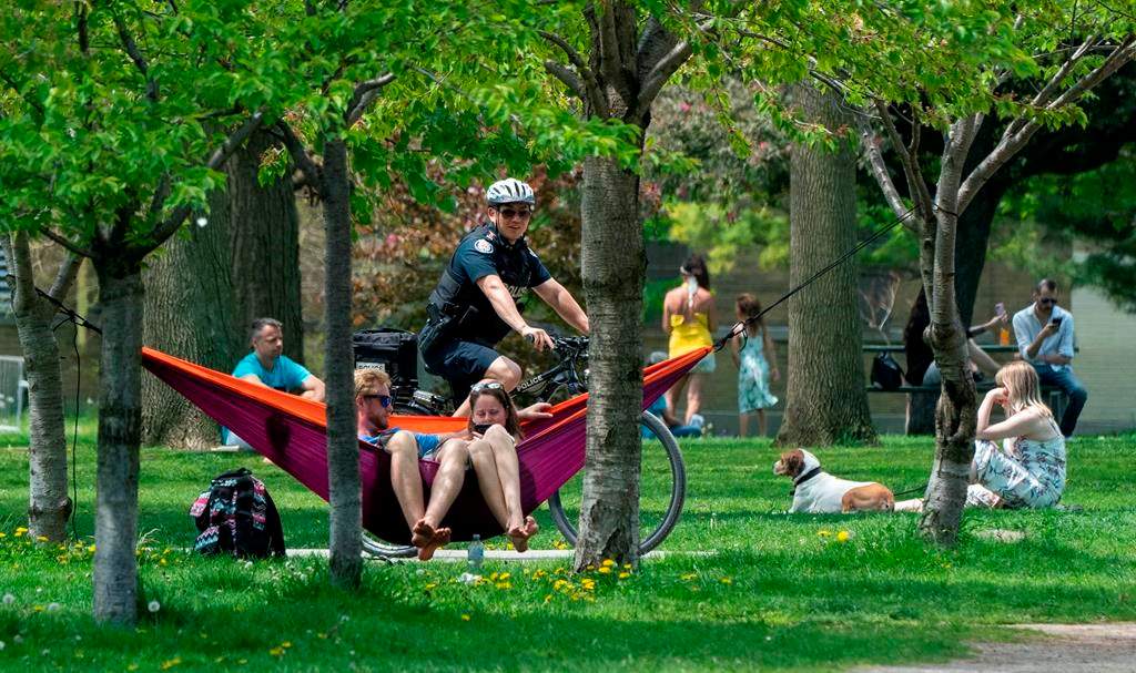 A bicycle police officer patrols Trinity Bellwoods Park in Toronto on Sunday, May 24, 2020. Warm weather and a reduction in COVID-19 restrictions has many looking to the outdoors for relief.