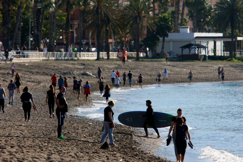 Adults walk and exercise at the beach on the first day that the government allows them to go out for sports individually and to walk with another person with whom they live, at certain times and up to a kilometre away from home on May 2, 2020 in Malaga, Spain.