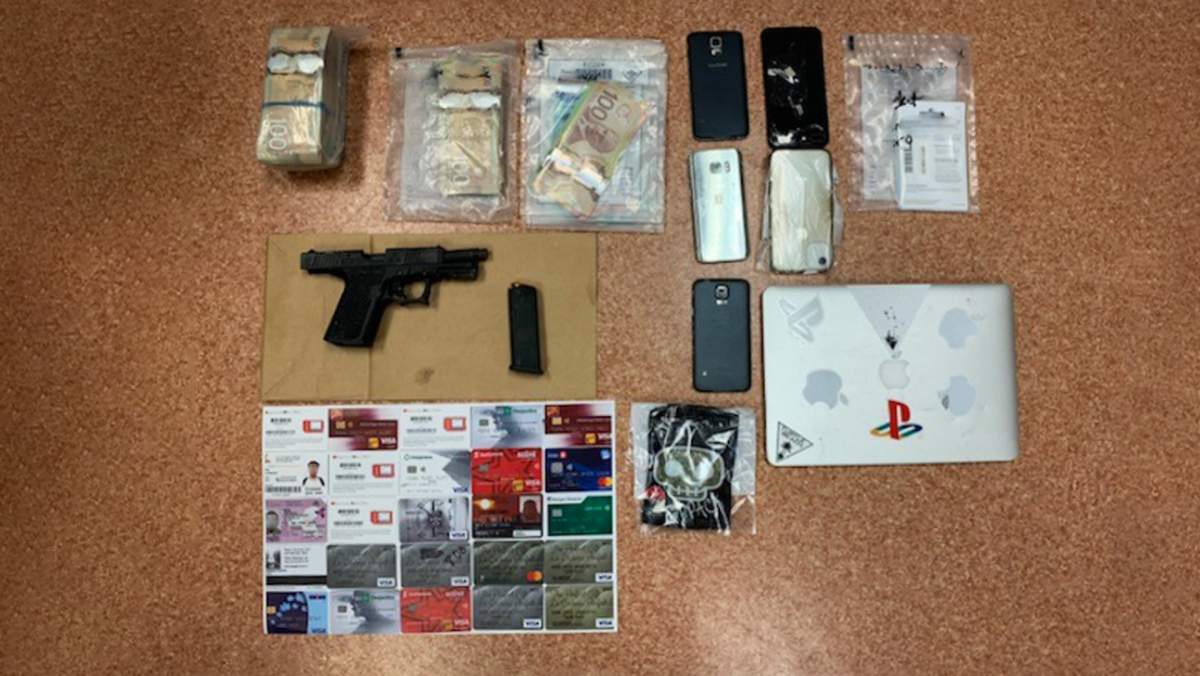 OPP say they seized a large amount of cash, a gun and several credit and debit cards from three men travelling in an SUV in Loyalist Township.