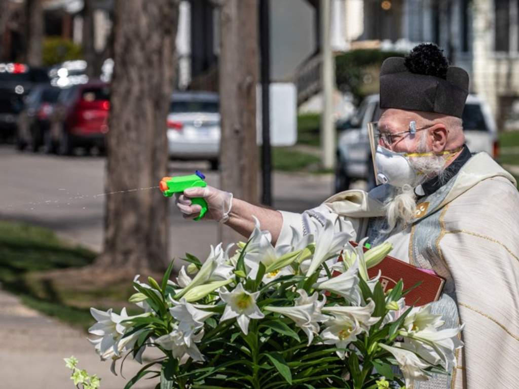 Rev. Tom Pelc of St. Ambrose Parish in Detroit, Mich., blessed churchgoers with a water gun full of holy water.