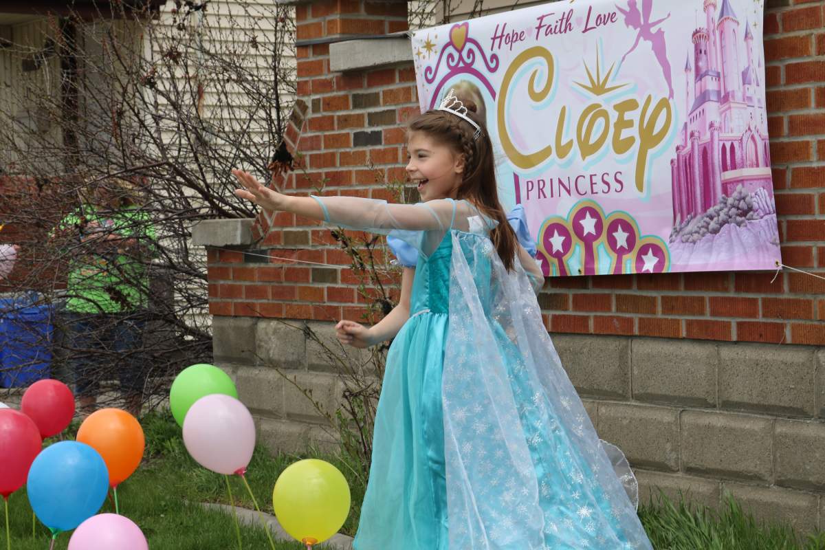 Cloey Prince waving at people at the parade outside her home in London Ont.