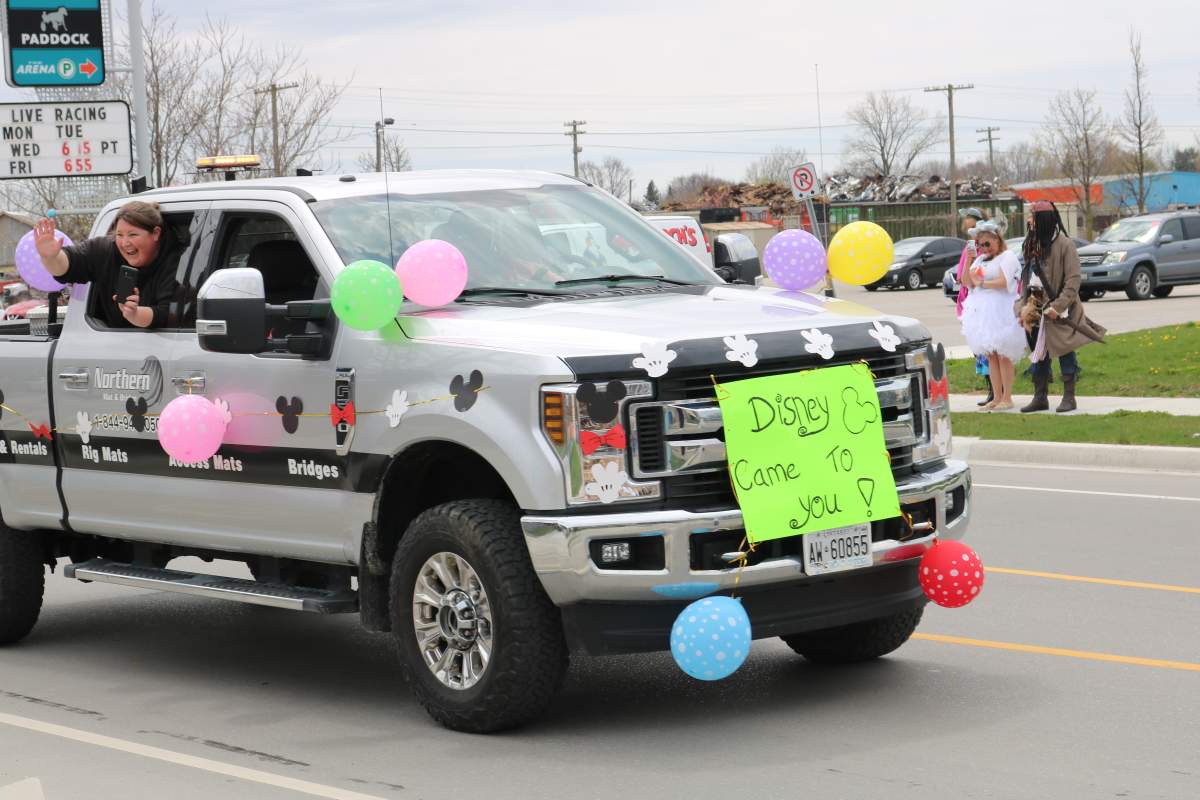 Truck with signs and people waving in the Disney Drive by for Cloey Prince in London Ont.