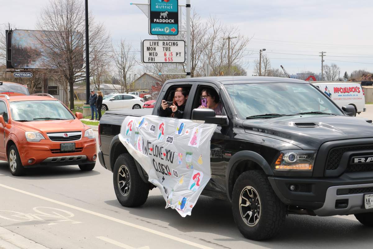 Truck with signs and people waving in the Disney Drive by for Cloey Prince in London Ont.