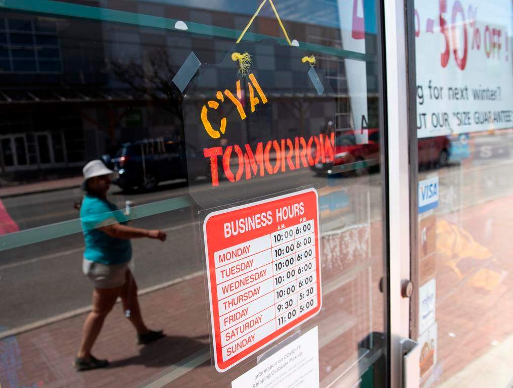 A sign on a closed shop welcomes shoppers to return tomorrow, in Ottawa, on Monday, May 18, 2020.