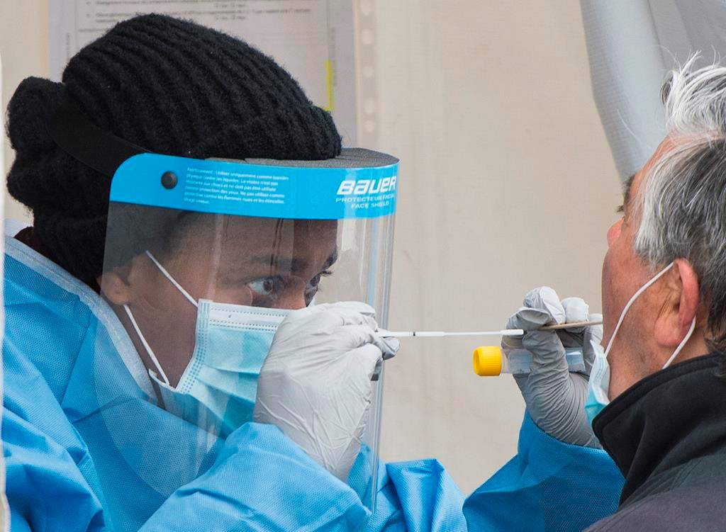 A health-care worker prepares to swab a man at a walk-in COVID-19 test clinic as the COVID-19 pandemic continues in Canada and around the world. THE CANADIAN PRESS/Graham Hughes.