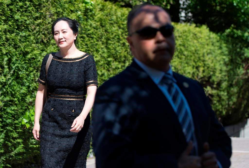 A security guard looks on as Meng Wanzhou, chief financial officer of Huawei, leaves her home to go to B.C. Supreme Court in Vancouver, Wednesday, May 27, 2020. THE CANADIAN PRESS/Jonathan Hayward.