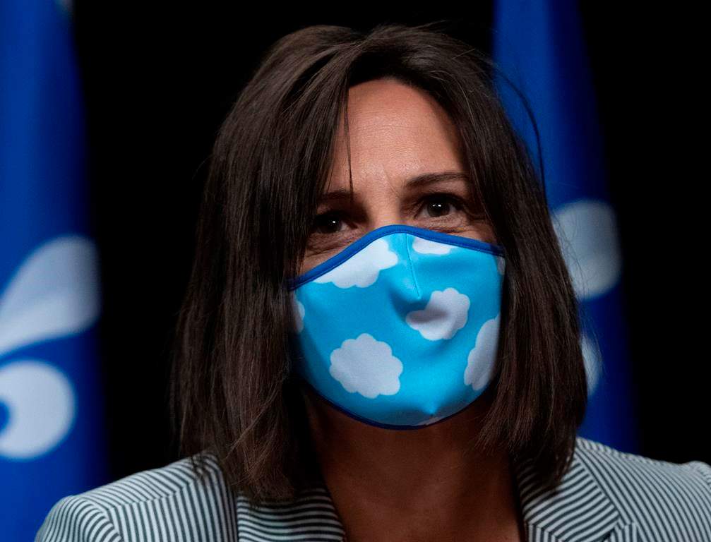 Quebec junior Education Minister and minister responsible for the status of women Isabelle Charest walks in wearing a mask.