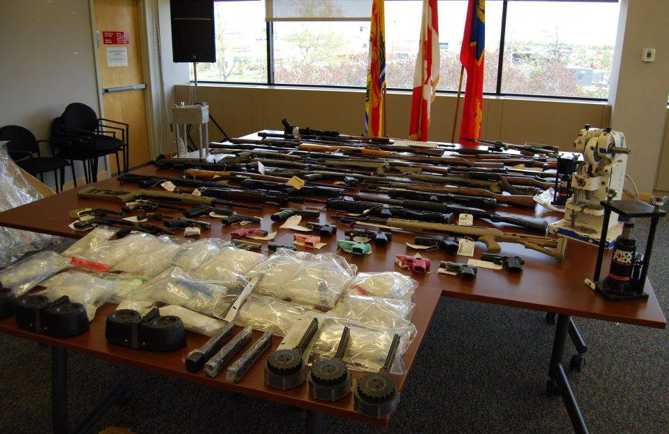 Police say 53 firearms, ammunition, methamphetamine, cocaine and cash was seized from the home. 