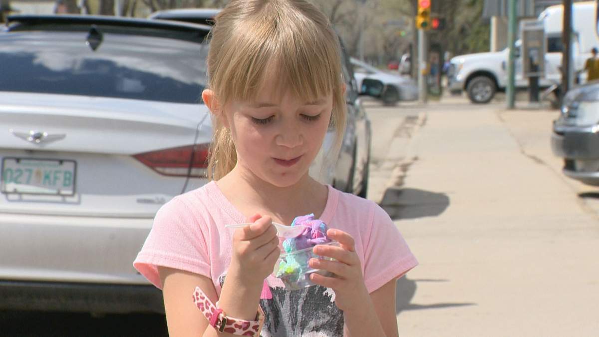 A Milky Way customer enjoys her treat on Wednesday, the first day the popular ice cream shop reopened for the season.