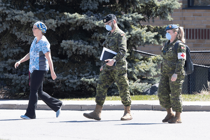 A staff member escorts members of the Canadian Armed Forces in to Orchard Villa Care home, in Pickering, Ont. on Saturday, April 25, 2020.