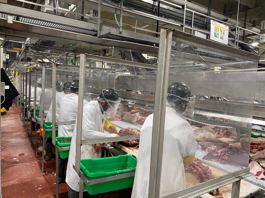 Workers inside the JBS beef processing facility work during the COVID-19 pandemic
