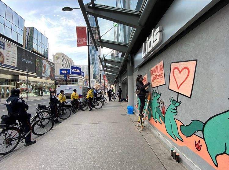 Street artist Emily May Rose paints a message of thanks to Toronto’s frontline workers.